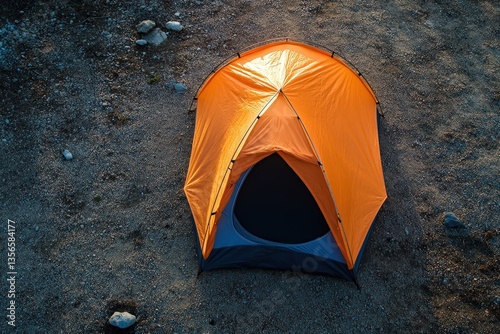An orange camping tent is set up outdoors on a surface