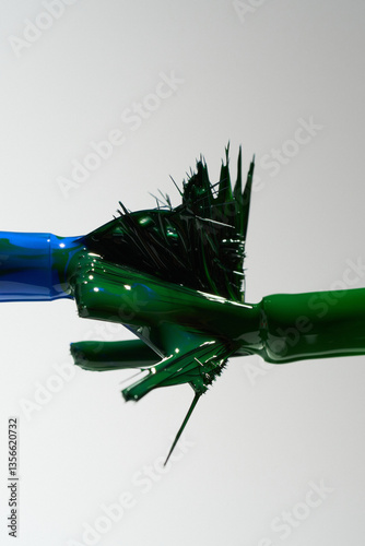 Bright blue green nail polish flows down the brush, macro, creative background, color mixing    