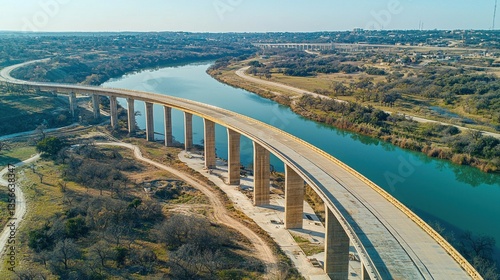 Elevated highway bridge over winding river, cityscapes in background