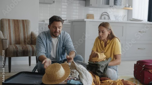 Arguing couple packing travel stuff for vacation into suitcases