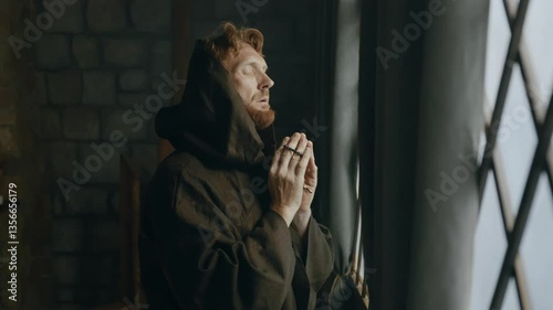Thoughtful medieval monk praying in cathedral