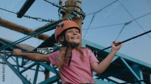 Little girl child feeling happiness due to successful climb in rope park