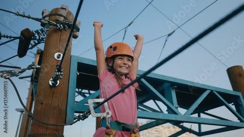 Excited little girl child feeling happiness due to successful climb in rope park