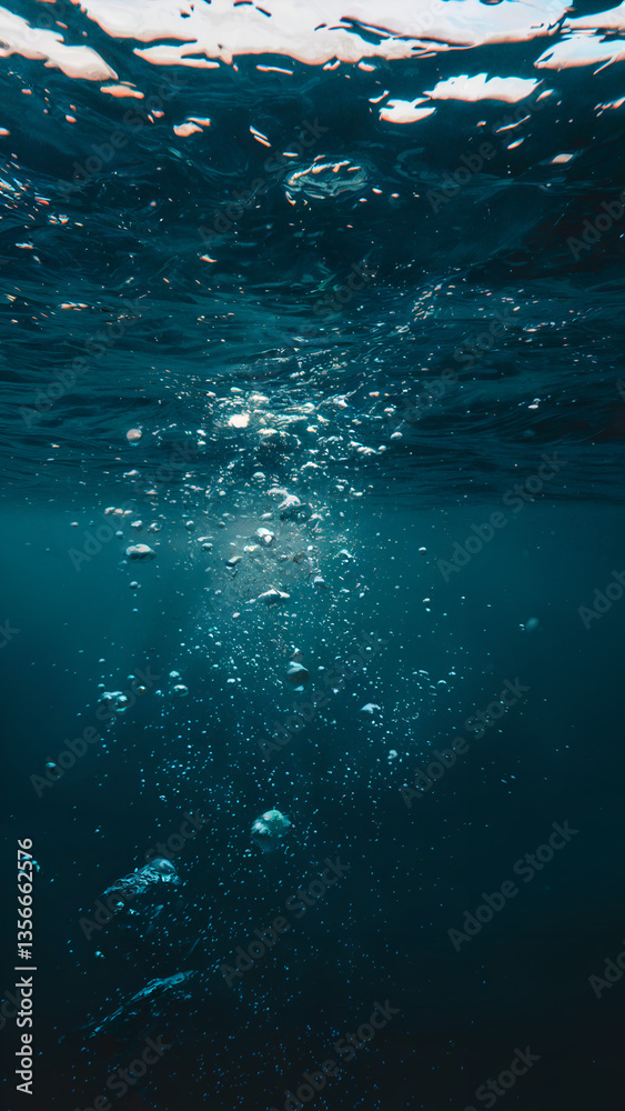 Obraz premium A deep blue underwater background with floating bubbles.