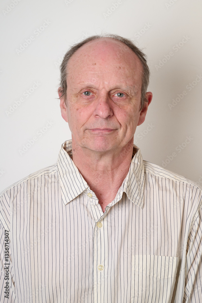Senior man with a cotton shirt against white wall