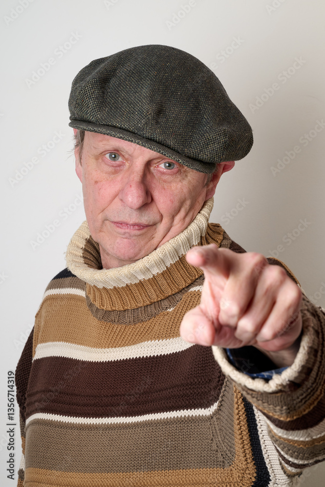 Senior man with a beige turtleneck puulover and a vintage cap
