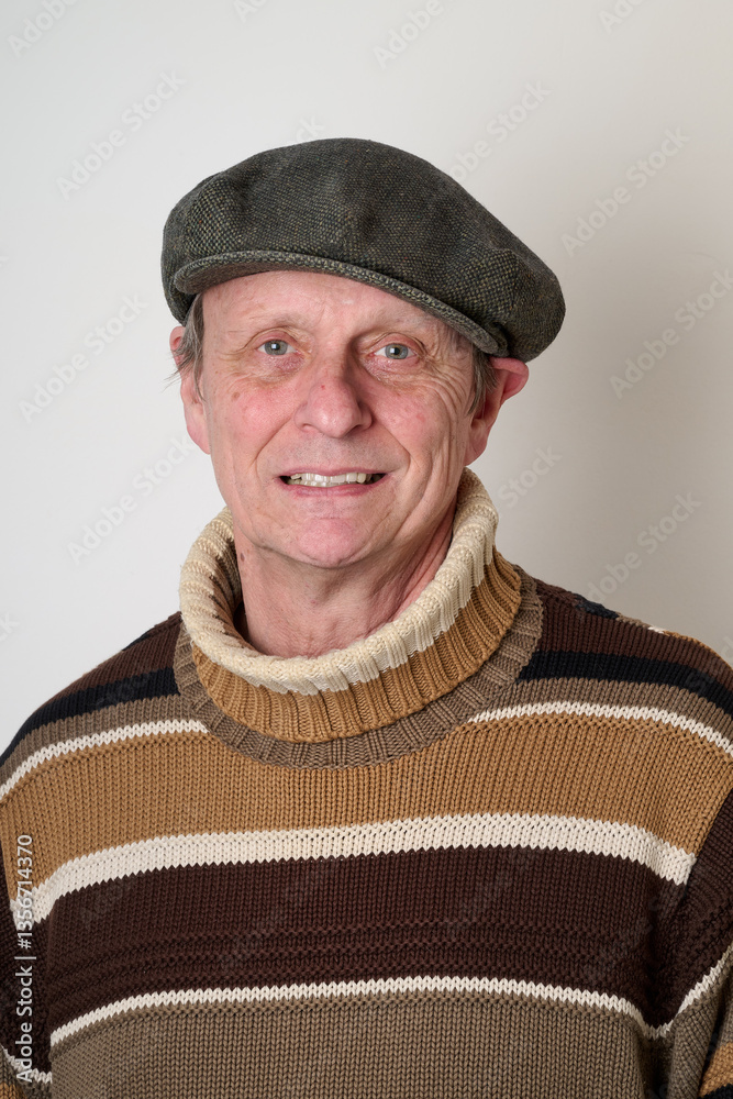 Senior man with a beige turtleneck puulover and a vintage cap