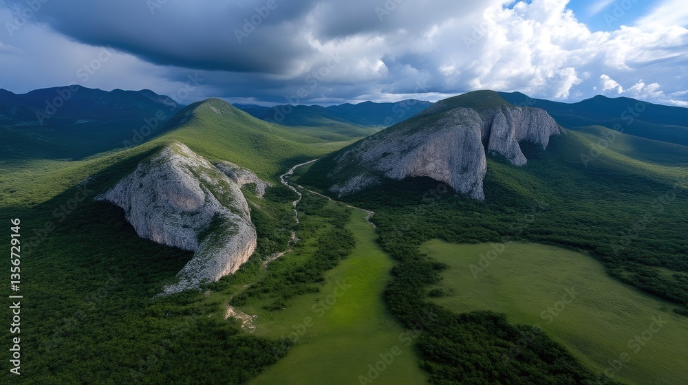 Aerial view of dramatic mountains and valley. Lush green landscape, rocky peaks, and a winding river carve through a valley Aerial view of dramatic mountains and valley. Lush green landscape, rocky peaks, and a winding river carve through a valley