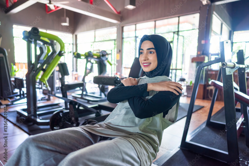Arab middle eastern muslim woman doing a stretching workout at the gym. Fitness exercise and healthy lifestyle concept