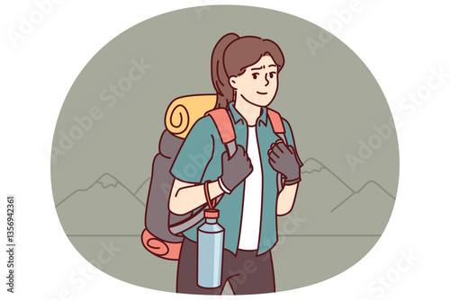 Woman tourist returns from hiking with large backpack on back and bottle of water posing near mountains. Girl is fond of hiking and loves to travel to natural parks and national reserves