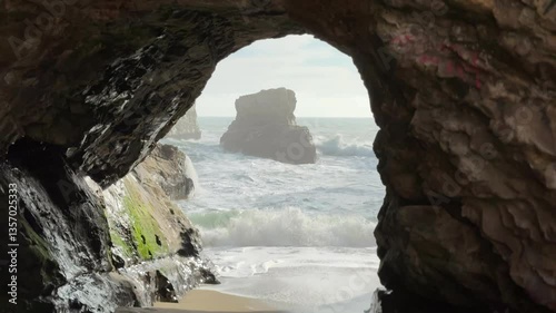 Shark Fin Cove beach with dramatic sea stack and visitors, Davenport, California