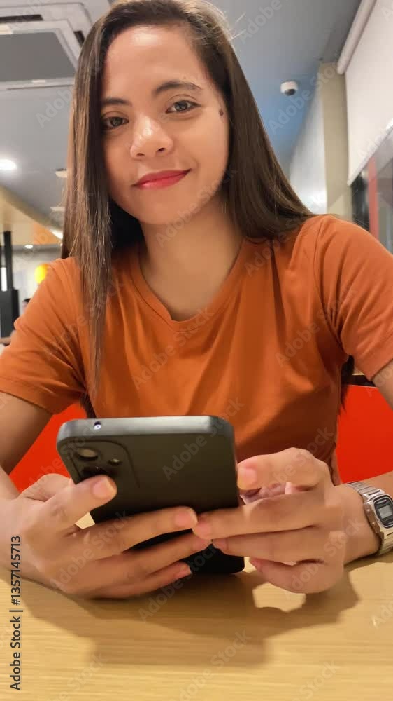 young woman in cafe waiting for order sitting at table and looking at smartphone young woman in cafe waiting for order sitting at table and looking at smartphone