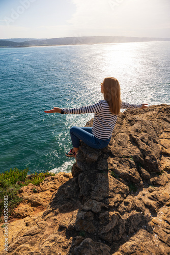 Obraz na płótnie Young woman looking at the view of ocean towards Praia do Norte. Nazare, Portugal w salonie