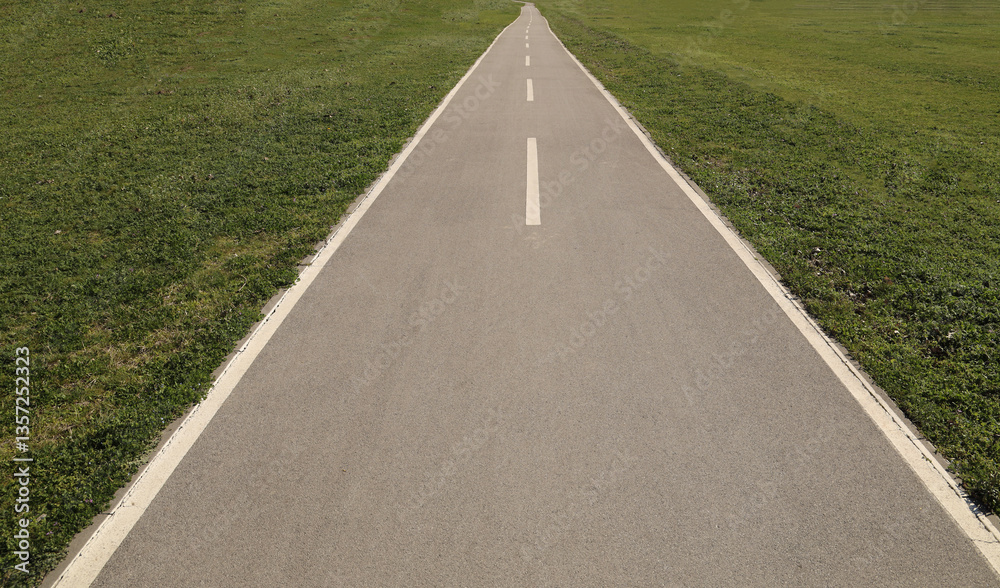Obraz premium empty long Asphalt road in perspective with blue sky. City urban park. Bicycle asphalt path in the park on a sunny day. mock up template. Belgrade Serbia