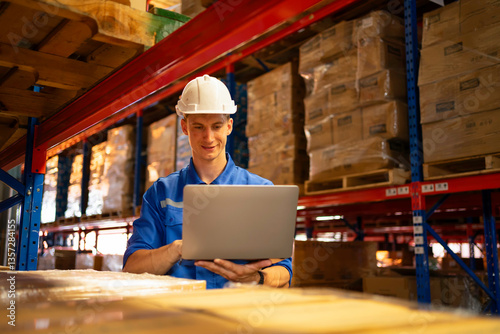 A warehouse worker uses a laptop to manage inventory, ensuring efficiency and safety in a modern industrial environment.