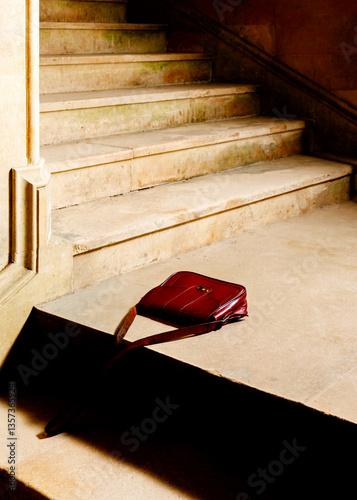 A purse was left abandoned on the stairs inside the house.