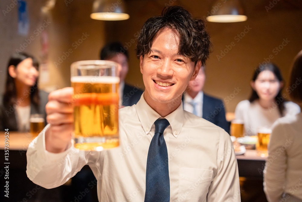 居酒屋でビールの乾杯をするサラリーマンの男性 居酒屋でビールの乾杯をするサラリーマンの男性