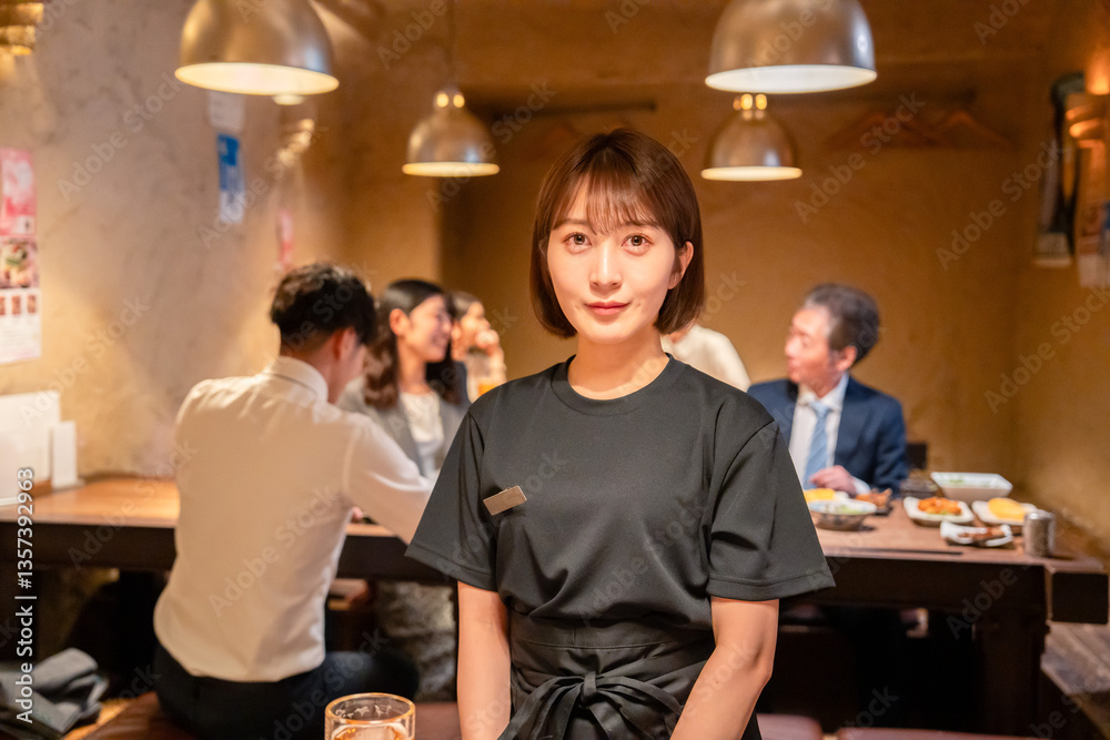 Obraz premium 居酒屋のホールで働く若い女性