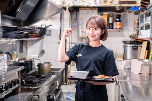 飲食店の厨房で働く若い女性のスタッフ