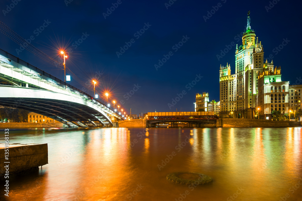 Obraz premium A high-rise building on Kotelnicheskaya embankment and Bolshoy Ustinsky bridge at night. Moscow