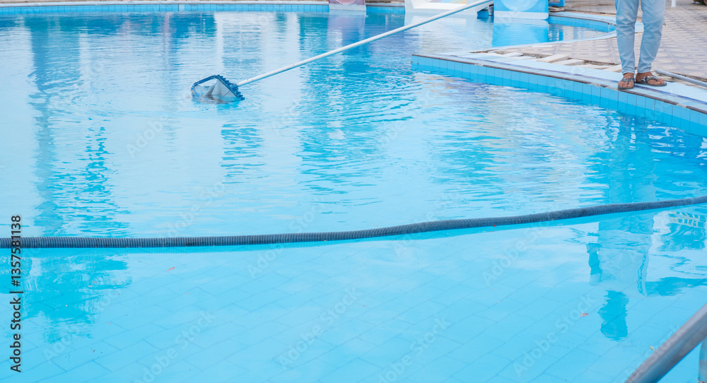 swimming pool cleaning. a man is cleaning the pool. service care