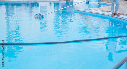 swimming pool cleaning. a man is cleaning the pool. service care