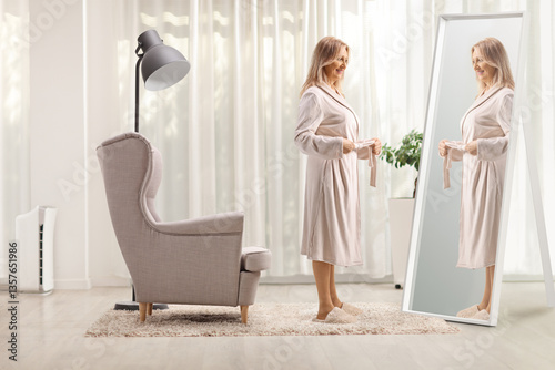 Woman putting on a bathrobe in front of a mirror