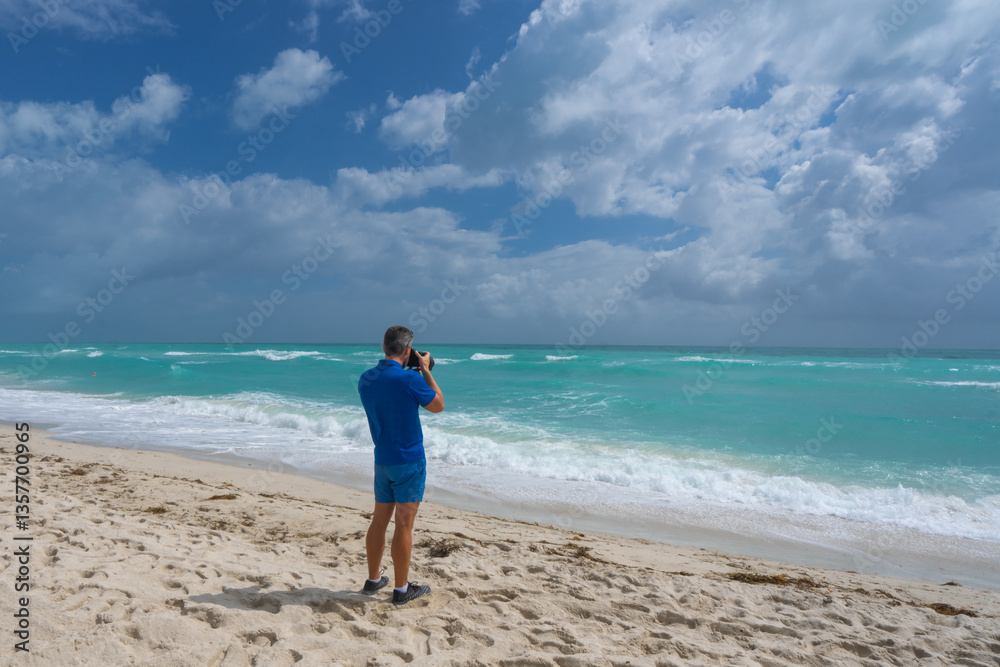 Man photographer with a camera on vacation. Summer photographer by the ocean. Tropical travel photography. Photograph of a man by the sea. Photographer capturing tropical views. Tourist photographer. Man photographer with a camera on vacation. Summer photographer by the ocean. Tropical travel photography. Photograph of a man by the sea. Photographer capturing tropical views. Tourist photographer.