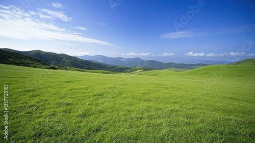 Lush green hills stretch under a vibrant blue sky, creating a serene and peaceful landscape in nature.
