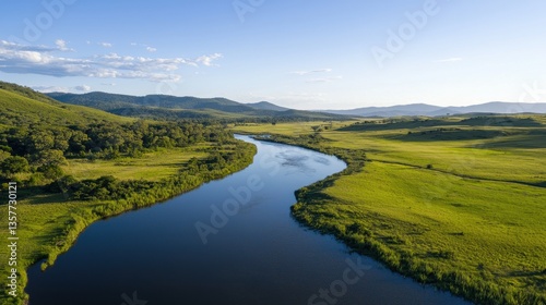 Wallpaper Mural A serene landscape featuring a winding river bordered by lush greenery and distant mountains under a clear blue sky. Torontodigital.ca
