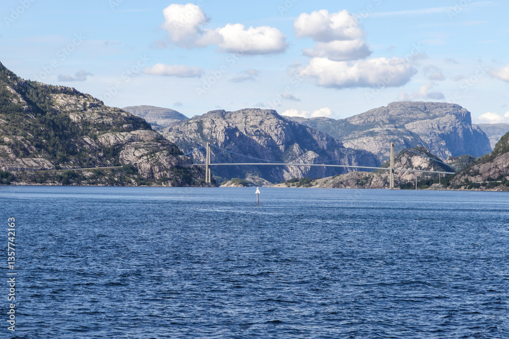 A bridge spans a body of water with mountains in the background in Norway fjord land A bridge spans a body of water with mountains in the background in Norway fjord land