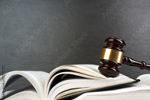 Law concept - Open law book with a wooden judges gavel on table in a courtroom or law enforcement office isolated on white table. Copy space for text.
