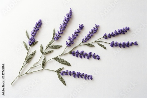 Intricate lavender embroidery on white fabric, showcasing delicate stitching and vibrant purple hues.