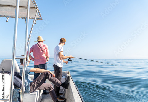 Three men fishing from a boat on the open sea