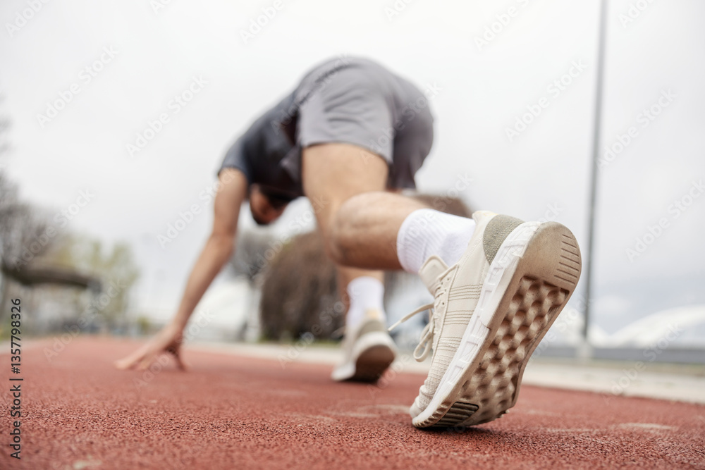 Fototapeta premium Close up of runner in starting position preparing for running.