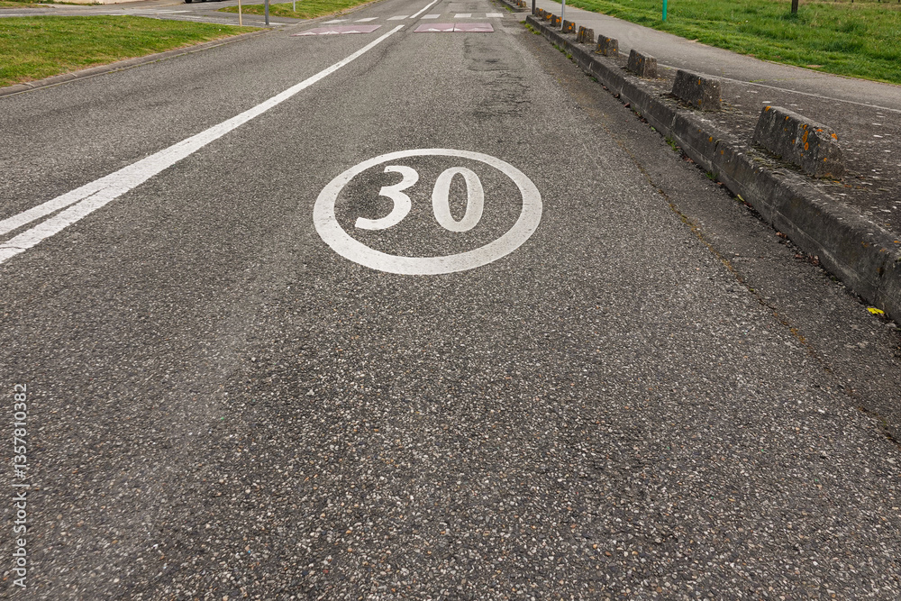 Speed limit sign indicating 30 km/h on a quiet road in a residential area
