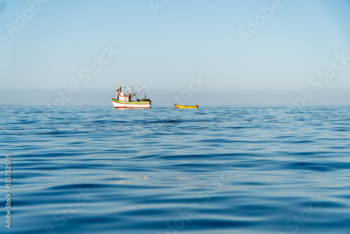 Obraz na płótnie Fishing Boat on the Horizon of a Calm Day at Sea w salonie