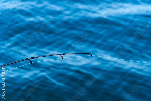 Obraz na płótnie Fishing rod tip over deep blue ocean background w salonie
