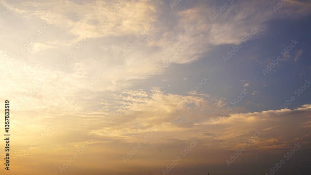 Fototapeta premium A stunning afternoon sky with bright yellow and blue gradations combined with white clouds scattered to form a beautiful natural pattern and beautiful yellow clouds, perfect for a background.