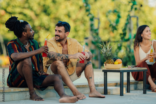 Friends enjoying summer vacation drinking cocktails by the poolside