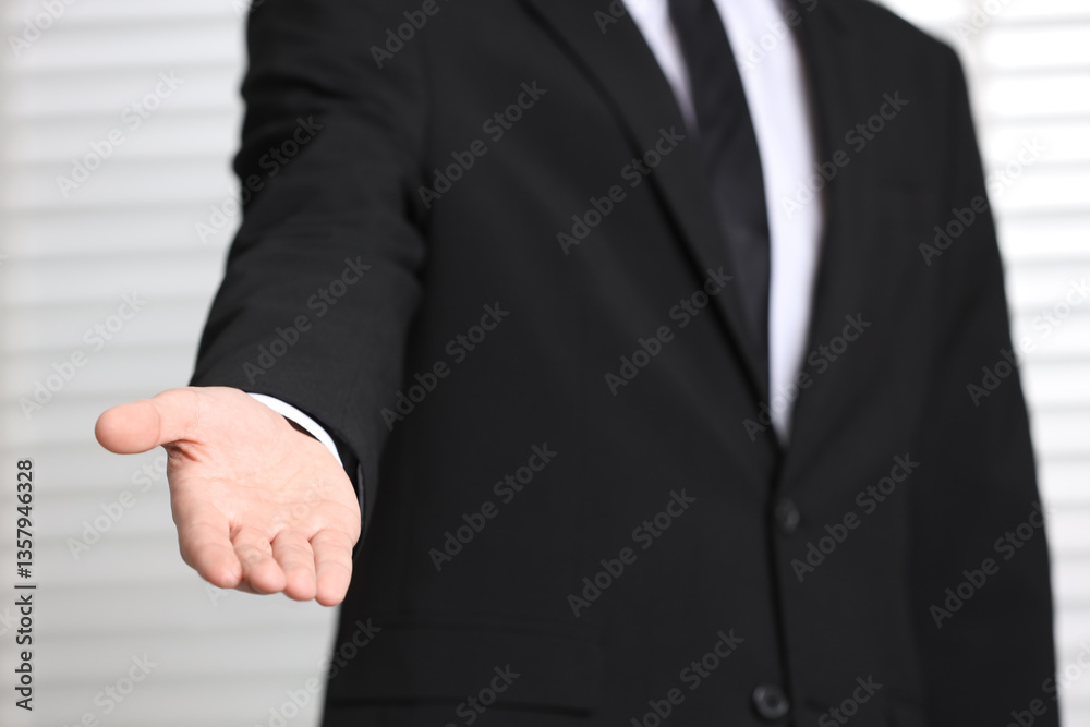 Man offering helping hand on light background, closeup Man offering helping hand on light background, closeup