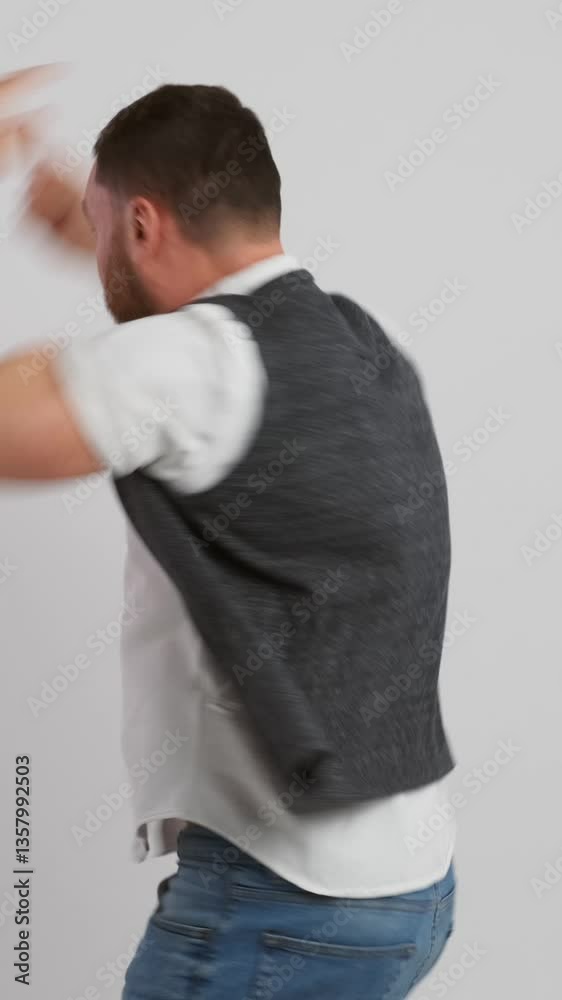 Playful and surprised, a man celebrating good news and success on a white background and shouting yes. Disbelief, joy, and excitement in the moment of achievement and celebration. Vertical video. Playful and surprised, a man celebrating good news and success on a white background and shouting yes. Disbelief, joy, and excitement in the moment of achievement and celebration. Vertical video.