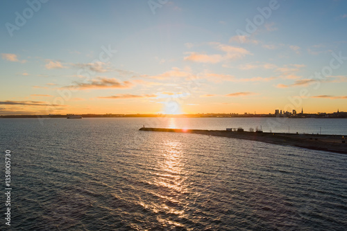 Sunrise over Tallinn Bay: Paljassaare, pier, calm water, and the city skyline in the distance.