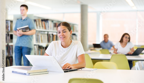 Smart female American student preparing for the exam in the school library