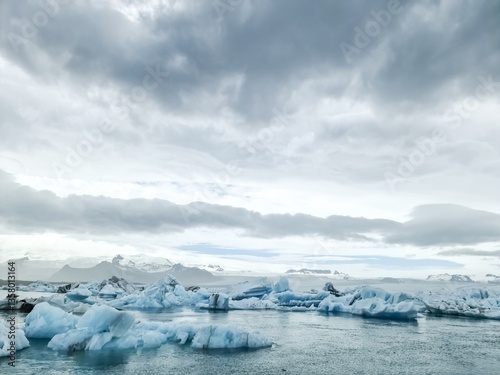 Icebergs floating in Jokulsarlon glacier lagoon in Iceland under cloudy sky photo