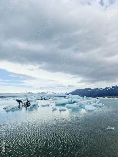 Icebergs floating on Jokulsarlon glacier lagoon in Iceland under cloudy sky photo