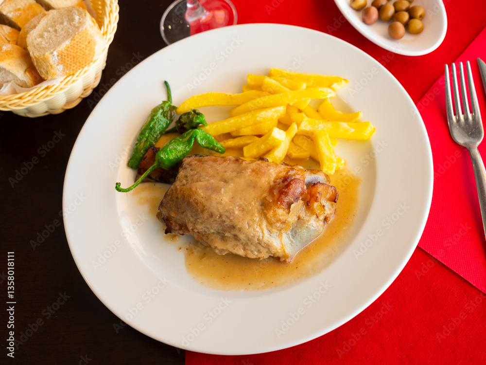 Appetizing beer roasted pork knuckle served with vegetable side dish of potatoes Appetizing beer roasted pork knuckle served with vegetable side dish of potatoes