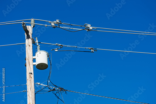 Vászonkép Electrical transformer mounted on a wooden pole connects to overhead power lines and insulators