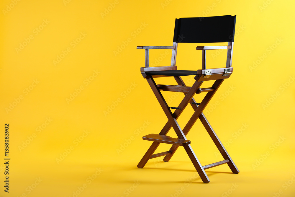 Fototapeta premium One empty director's chair on yellow background, space for text