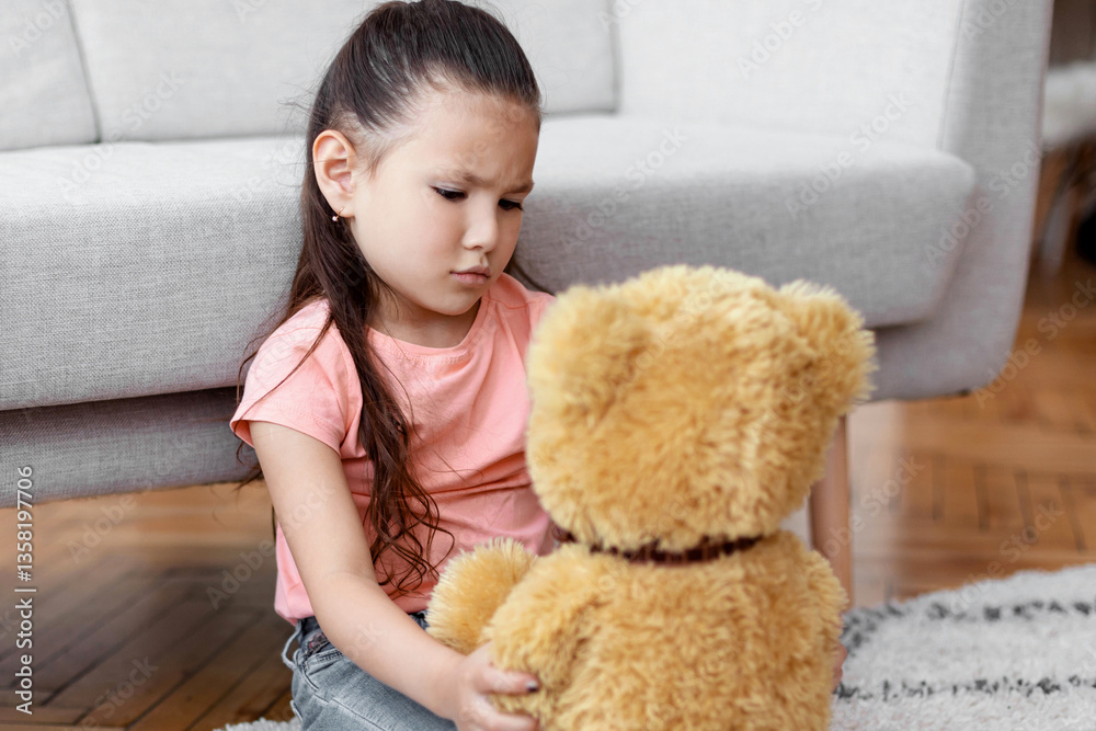 Kid's Loneliness. Depressed Kid Girl Holding Teddy Bear Sitting Alone At Home. Copy Space Kid's Loneliness. Depressed Kid Girl Holding Teddy Bear Sitting Alone At Home. Copy Space
